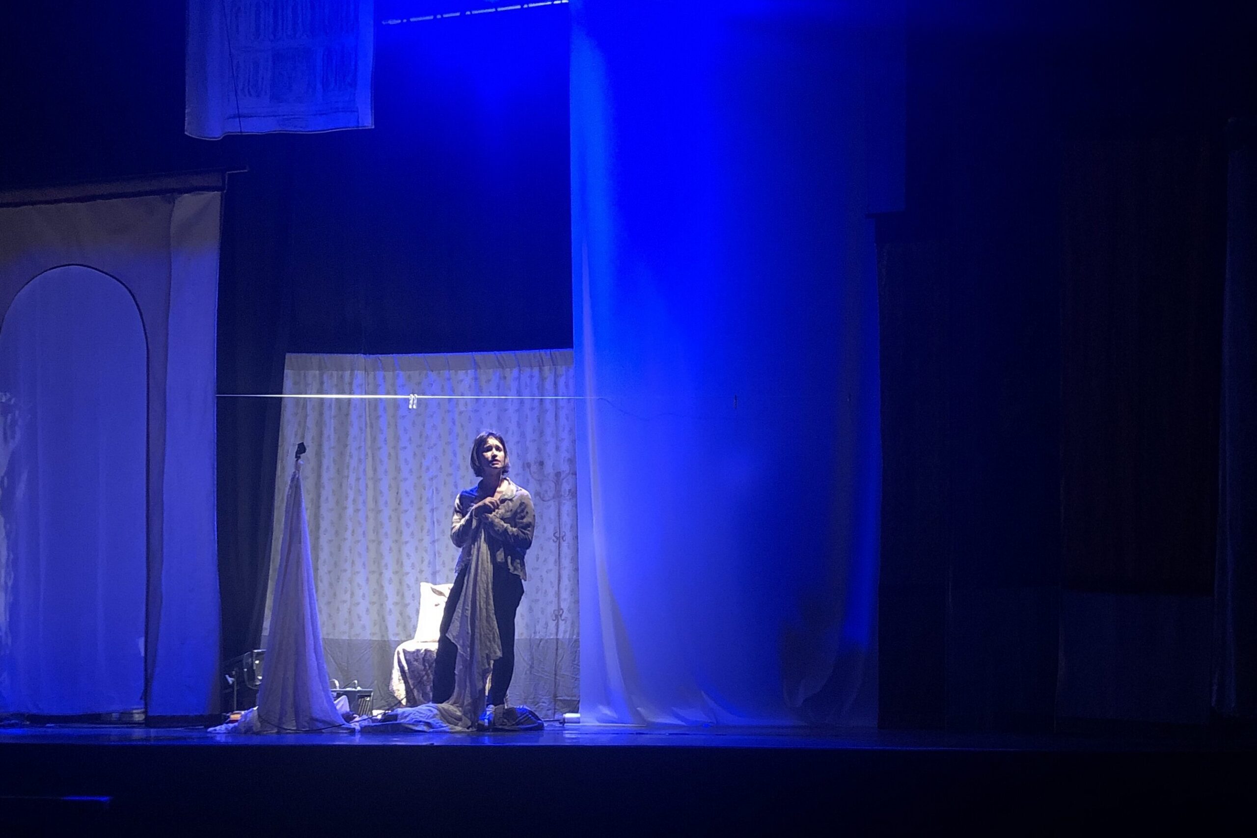 La fille au micro, seule, autour toutes les couches de tissus qui représente des strates de mémoire