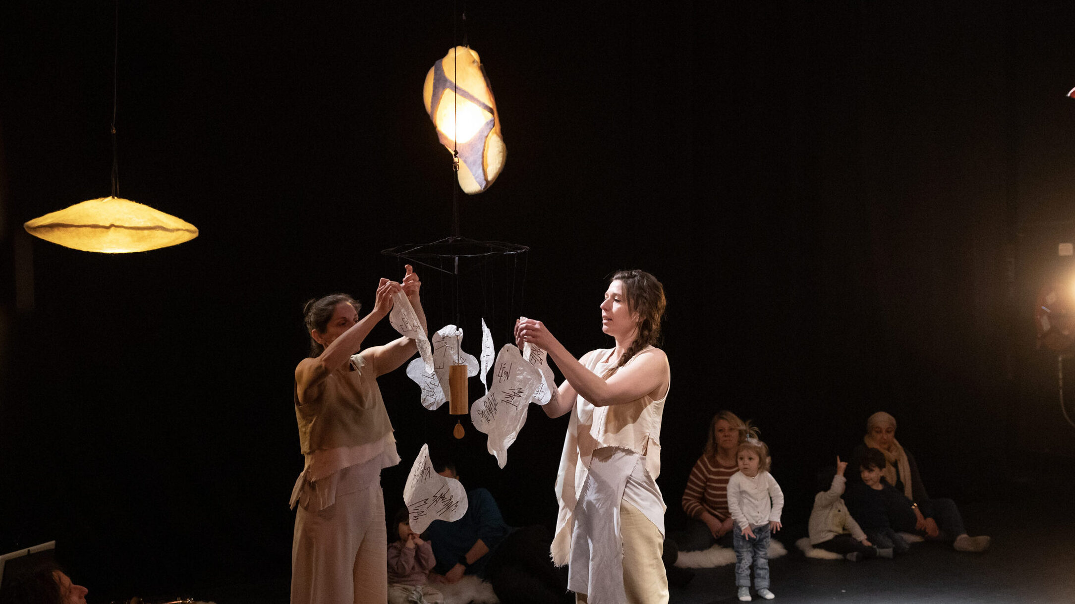 Hallux et Poplité lisent les prénoms écrie sur le mobile au centre de la scénographie